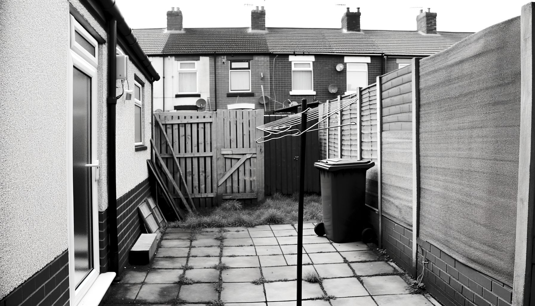 Small garden space beside a UK terraced property showing potential heat pump placement area